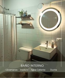 een badkamer met een toilet, een wastafel en een spiegel bij Casa Wadara in La Mira