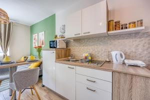 cocina con armarios blancos y encimera en Apartments with a parking space Delnice, Gorski kotar - 23045, en Delnice
