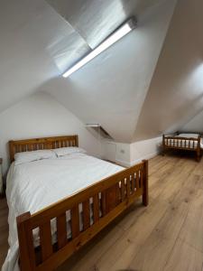 ein Schlafzimmer mit einem Holzbett im Dachgeschoss in der Unterkunft Lovely Home in Kimmage, Dublin in Dublin