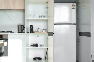 a kitchen with white cabinets and a refrigerator at Asteroid B-612 Urban Bliss Retreat in Melbourne