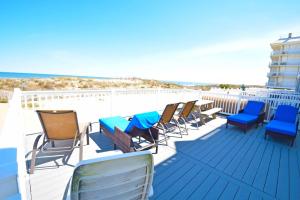 eine Reihe von Stühlen auf einer Terrasse mit Strand in der Unterkunft Ocean Club 4011 townhouse in Ocean City