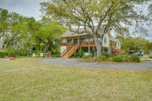 a large house with a tree in front of it at Wilmington Getaway with Dock and Masonboro Island View in Wrightsville Beach