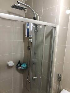 a shower with a glass door in a bathroom at SMDC 1 BR Grass Residence Tower 3 North Ave., QC in Manila