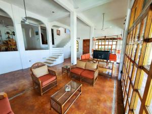 a living room with chairs and a table and a television at Villa Casalet in Puerto Escondido