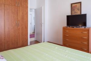 Dormitorio con cama y tocador con TV en Apartment Nevia, en Makarska