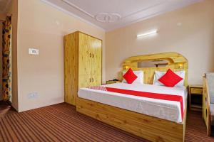una camera da letto con un grande letto con cuscini rossi di OYO Flagship Aman Cottage a Manāli