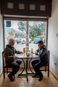 チバイにあるYARAVI Hostal Restauranteの窓際のテーブルに座る二人