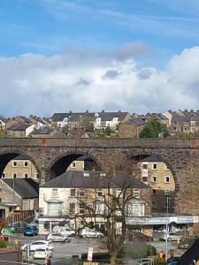 a stone bridge over a parking lot with buildings at Fern House - free off road parking included in Buxton