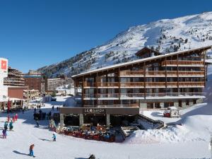 un lodge de esquí en una montaña con gente en la nieve en Modern apartment located in the extensive Paradiski ski area, en Arc 2000