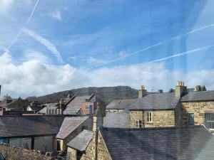 una vista de los tejados de las casas con montañas en el fondo en Fern House - free off road parking included, en Buxton