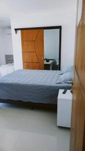 sypialnia z łóżkiem i dużym lustrem w obiekcie Pousada Família Eleutério w mieście Penha