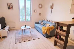 - un salon avec un canapé bleu et une table dans l'établissement Seine view at heart of the Seine/Oise Confluence, à Conflans-Sainte-Honorine