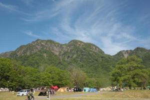 um grupo de tendas e veículos em frente a uma montanha em Togakushi Campsite - Vacation STAY 42172v em Shinano