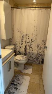 een badkamer met een toilet en een douchegordijn bij DOWNTOWN, LUXURY CONDO, CN TOWER, ROGERS CENTER, SCOCIA ARENA, UNOBSTRUCTED VIEW in Toronto