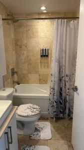 een badkamer met een toilet, een bad en een douche bij DOWNTOWN, LUXURY CONDO, CN TOWER, ROGERS CENTER, SCOCIA ARENA, UNOBSTRUCTED VIEW in Toronto