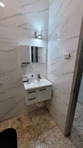 ein weißes Badezimmer mit einem Waschbecken und einem Spiegel in der Unterkunft Adorable Arouca 1BDR Apartment in Arouca