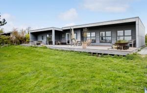ein Haus mit einer großen Terrasse und einem grünen Feld in der Unterkunft Stunning Home In Holbk With Kitchen in Holbæk