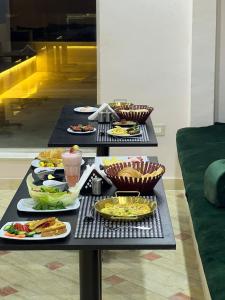 een tafel met meerdere borden voedsel erop bij Tuya Queen Pyramids View in Caïro