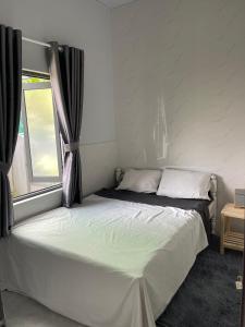 a white bed in a room with a window at Cle homestay in Hue