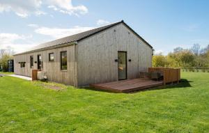 ein kleines Gebäude mit einer Terrasse im Gras in der Unterkunft Cozy Home In Fllenslev With Wifi in Føllenslev