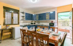 cocina con mesa y sillas y cocina con armarios azules en Nice Home In Alcala La Real With Kitchen, en Alcalá la Real