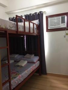 2 Etagenbetten in einem Zimmer mit Fenster in der Unterkunft XnY@SMDCTreesResidences1BedT1 Fairview Quezon City in Manila