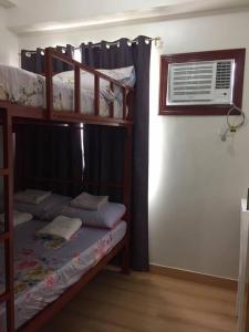 Zimmer mit 2 Etagenbetten und einem Fenster in der Unterkunft XnY@SMDCTreesResidences1BedT1 Fairview Quezon City in Manila