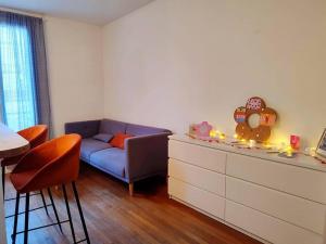 ein Wohnzimmer mit einem blauen Sofa und einer Kommode in der Unterkunft Cocon urbain aux portes de Paris/parc Montsouris in Montrouge