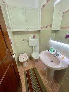 a bathroom with a sink and a toilet at Quarto de Casal Acolhedor in Laranjeira