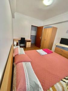 a bedroom with two beds and a desk and a desk at Quarto de Casal Acolhedor in Laranjeira