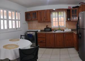 a kitchen with wooden cabinets and a table with a white table cloth at Hostal Palmas De Punta Cana in Punta Cana