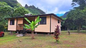 una pequeña casa con una palmera delante de ella en MOOREA - Oceanie Lodge, en Pihaena