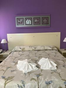 uma cama com duas almofadas num quarto em HOTEL LOS TILOS RECONQUISTA em Reconquista