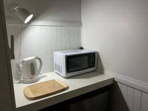 a microwave sitting on a counter with a cutting board at Black Range Lodge in Tumbarumba