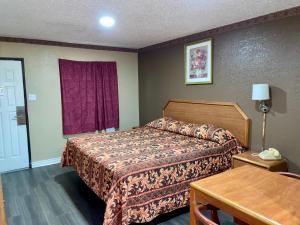 ein Hotelzimmer mit einem Bett und einem Tisch in der Unterkunft Ankur Inn Motel in Dallas