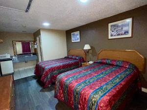 a hotel room with two beds and a tv at Ankur Inn Motel in Dallas