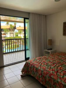 um quarto com uma cama e vista para uma varanda em Marulhos Resort - 1 quarto em Porto de Galinhas