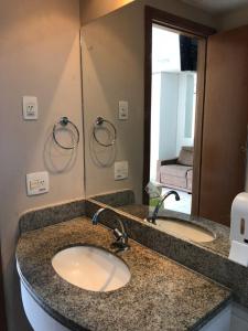 uma casa de banho com 2 lavatórios e um espelho grande em Marulhos Resort - 1 quarto em Porto de Galinhas