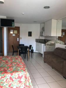 sala de estar y cocina con sofá y mesa en Marulhos Resort - 1 quarto en Porto De Galinhas
