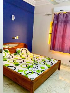 um quarto com uma cama com uma colcha colorida em Résidencesdavelsa em Cotonou