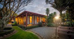 a house with a bench in a garden at Last Resort Karamea in Karamea