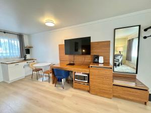 a room with a desk with a tv and a mirror at Ukee Peninsula Motel in Ucluelet