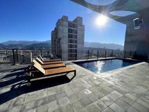 un banco sentado en la parte superior de un edificio con piscina en Entire apartment with unique view at the best location, en Monterrey