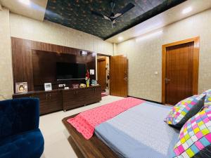 a bedroom with a bed and a flat screen tv at Shreshth Home Stay - Best Family Accommodation - 3km from Har Ki Pauri, Haridwar, Uttarakhand in Haridwār