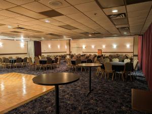 una sala de conferencias con mesas y sillas. en Kearney Inn and Convention Center, en Kearney
