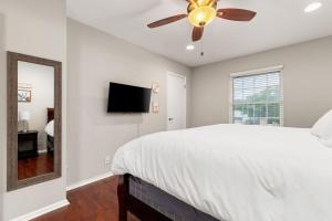 um quarto com uma cama, uma ventoinha de tecto e um espelho. em Spacious 4 bedroom with pool-Minutes to Seaworld! em San Antonio