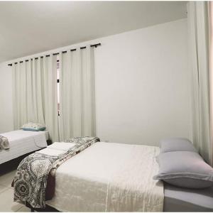 Hotel pernoite في باتو برانكو: غرفة نوم بيضاء بها سرير ونافذة
