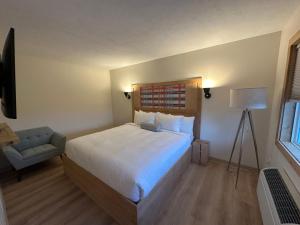 una camera con un grande letto bianco e una sedia di Explorer Rest & Recreation a Sandusky