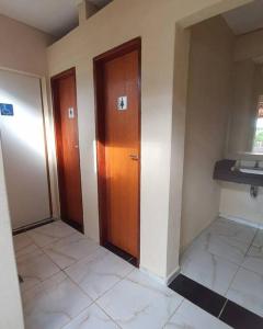 pusty pokój z dwoma drzwiami i podłogą wyłożoną kafelkami w obiekcie Chácara Urbana Quiosque Canto do Curió w mieście Araxá