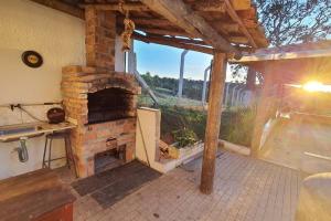 uma cozinha exterior com uma lareira de tijolos num pátio em Chácara Urbana Quiosque Canto do Curió em Araxá